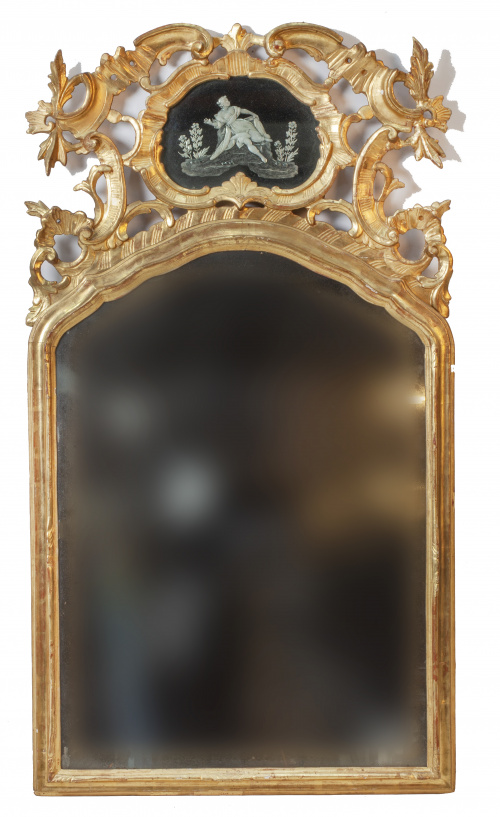 Espejo de madera tallada, estucada y dorada, rematado por e