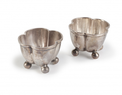 Dos especieros de plata con forma lobulada y patas de bola,