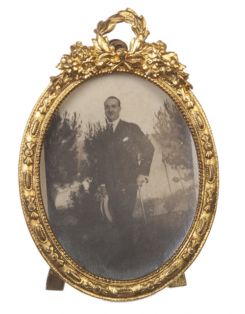 Pequeño marco en bronce dorado rematado por guirnalda.Fra