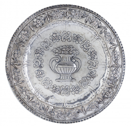 Bandeja circular en plata repujada con un jarrón con flores