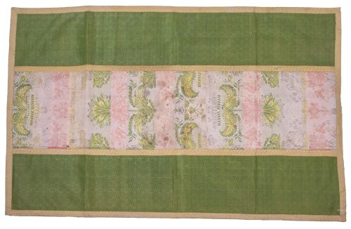 Tela con flores aplicada con galones sobre tela verde.Esp