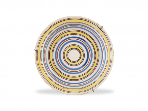 Plato de cerámica esmaltada con círculos concéntricos.Man