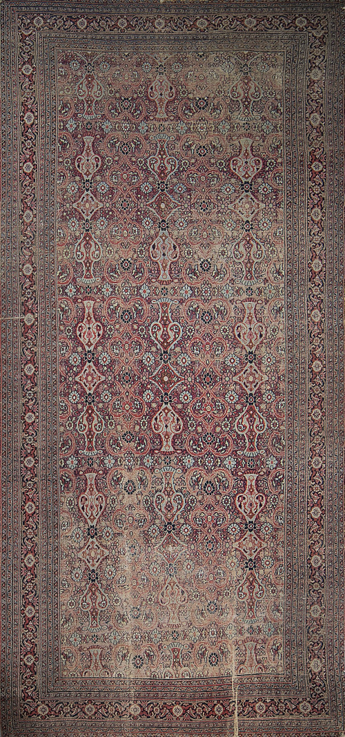 Alfombra persa antigua con profusa decoración.