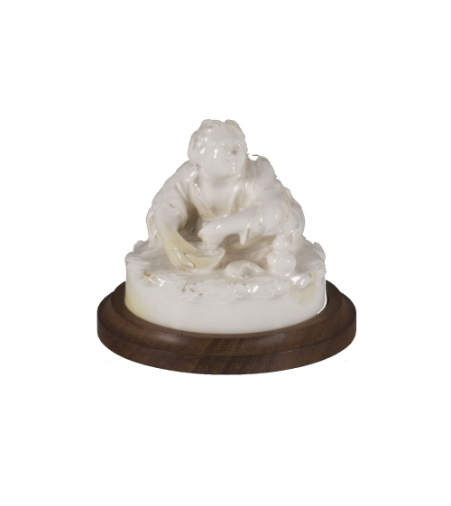 Tapa de caja modelada en forma de niño comiendo.Alcora, te