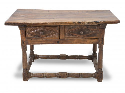 Mesa de madera de nogal con cajones tallados en el frente.