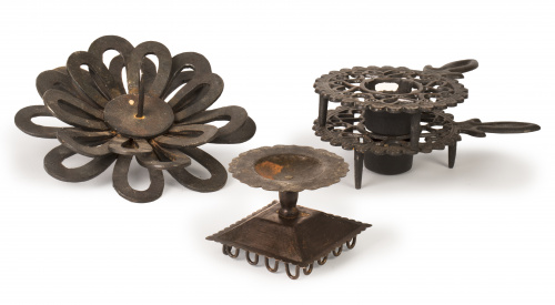 Conjunto de cuatro candeleros de hierro, con diferentes for