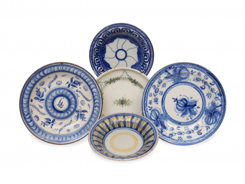 Cinco platos de cerámica esmaltada, alguno en azul de cobal