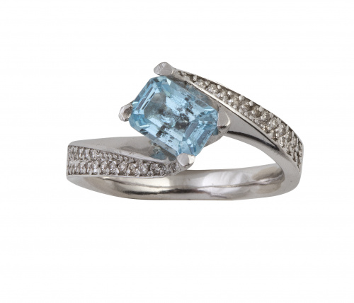 Sortija con topacio azul de talla rectangular entre dos bra