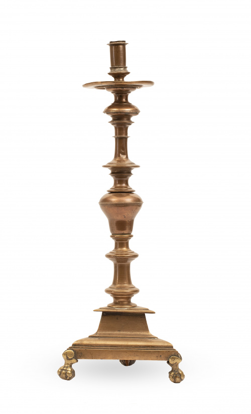 Candelero de bronce con patas de garra sobre bola.Trabajo