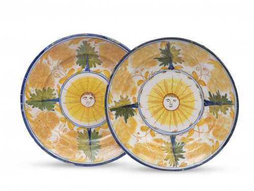 Pareja de platos de cerámica esmaltada con soles en el asie