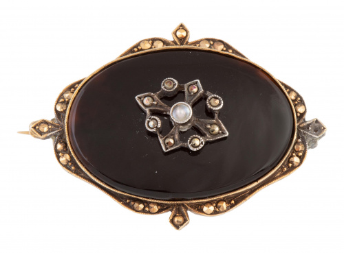 Broche oval de pp. S. XX de ónix con rosetón central y marc