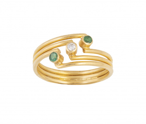 Sortija con brillante entre dos esmeraldas en frente oblícu