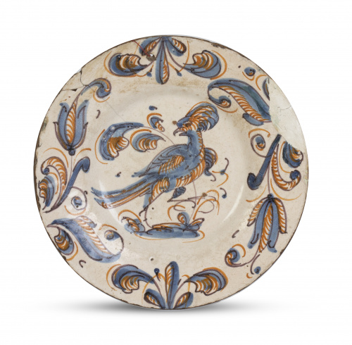 Plato de cerámica esmaltada con pájaro y hojas en el asient