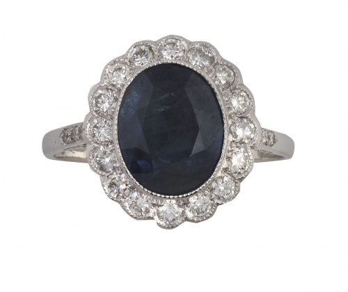 Sortija con zafiro oval central orlado de brillantes 