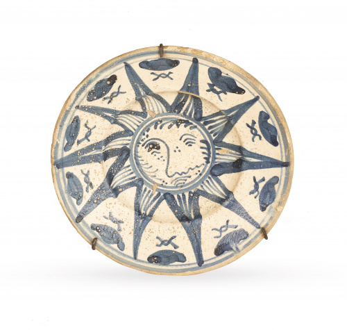 Plato de cerámica esmaltado en azul cobalto con un sol en e