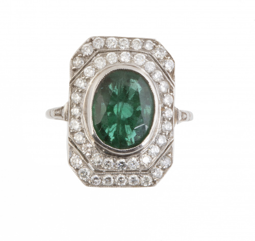 Sortija con esmeralda oval central sobre marco rectangular 