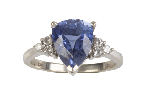 Sortija con piedra azul central talla pera flanqueado por t