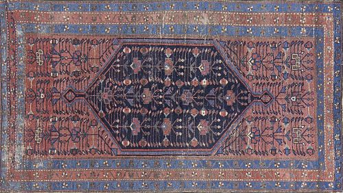 Alfombra en lana con campo rojo y motivos azules.