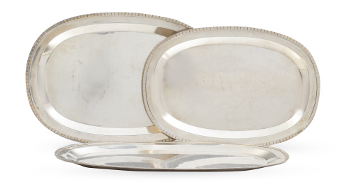 Lote de tres fuentes ovales de plata, decoradas con banda d