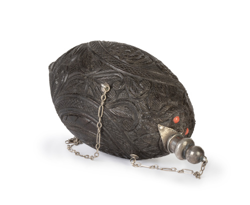 Polvorera en nuez de coco tallado con flores en medallón.