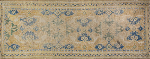 Alfombra en lana en melado, azul y ocre, con arabescos "tip