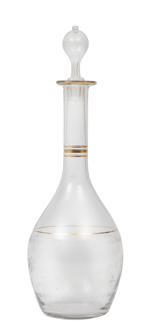 Garrafa de vidrio con flores talladas y círculos en dorado.