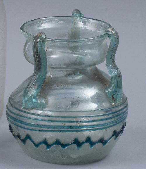 Garrafa de vidrio transparente y azul, con tres asas.Trab