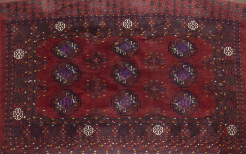 Alfombra antigua de colección, de campo granate y elementos