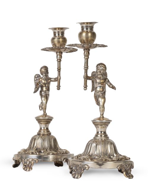 Pareja de candeleros de plata con "puttis".Uno con etique
