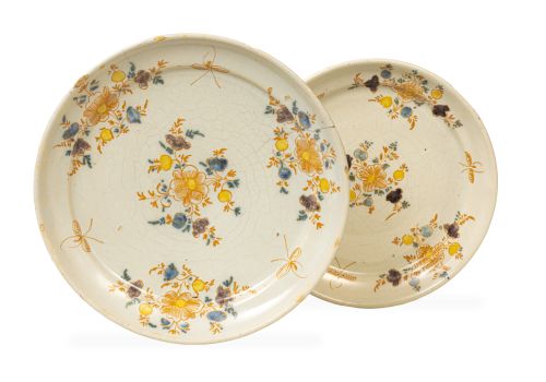 Dos platos de cerámica esmaltada con decoración floral, de 