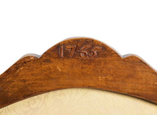 Silla de brazos de madera tallada, fechada en el reverso "1