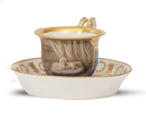Taza con su plato de porcelana esmaltada y dorada, con perr