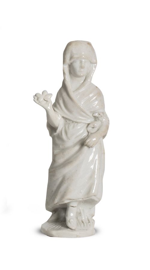 Figura femenina de porcelana blanca, con flor en la mano.