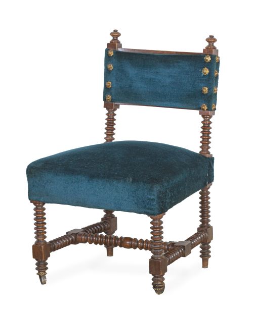 Silla baja de madera torneada con tapicería en azul tachona