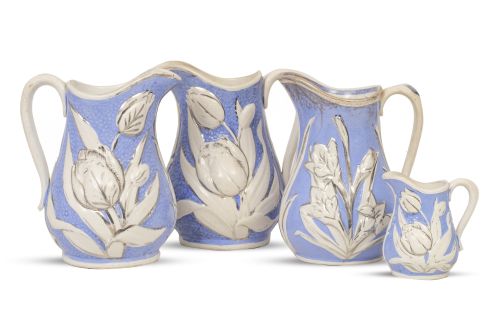 Lote de cuatro jarras de loza esmaltada en azul y blanco y 