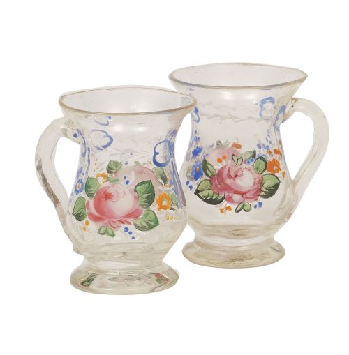 Pareja de jarritas de vidrio pintado con flores esmaltadas.