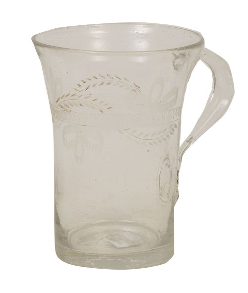 Jarra de vidrio transparente con decoración grabada y resto